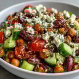 A close-up shows Greek Bean Salad with ripe cherry tomatoes, Kalamata olives, and creamy feta cheese over a bed of marinated beans.