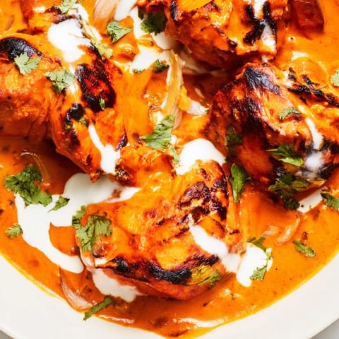 Homemade Chicken Tikka Masala served with fluffy basmati rice and warm naan bread on the side.