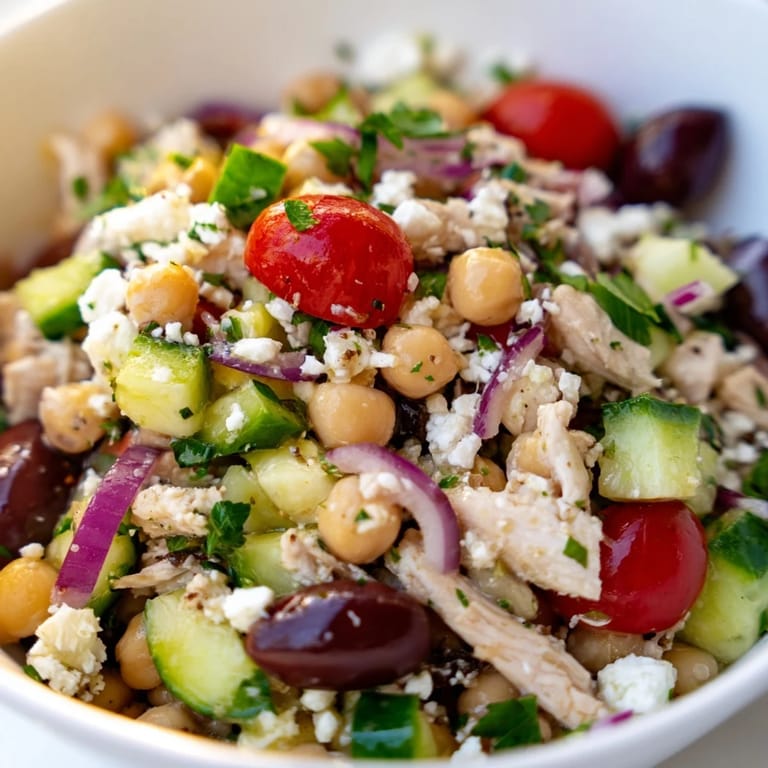 Close-up shot showing diced chicken, chickpeas, tomatoes, and cucumber, ready to serve for a light dinner.