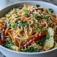 A close-up of Shirataki Noodle Bowl with colorful vegetables like bok choy and red bell pepper in a savory ginger sauce.